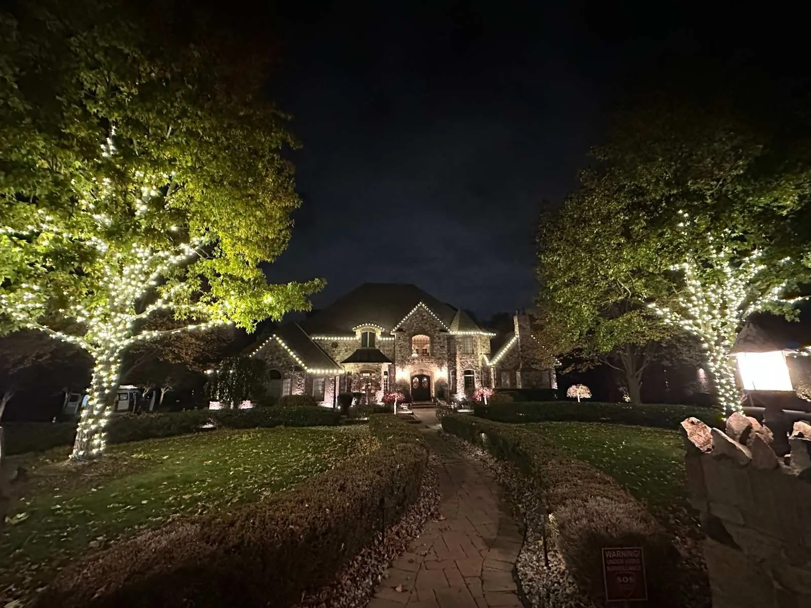 Estate with lit trees and roofline