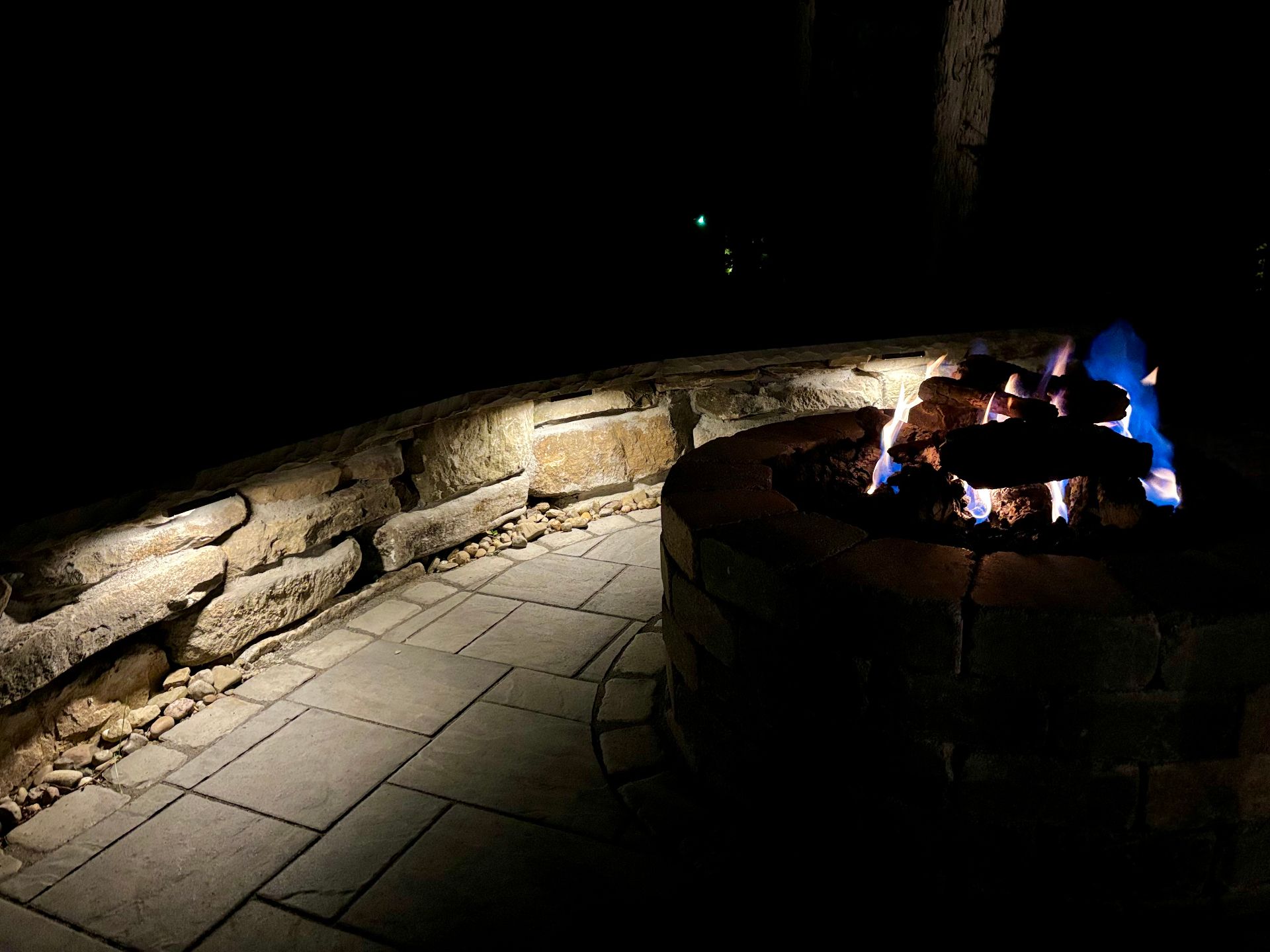 Outdoor fire pit with landscape lighting