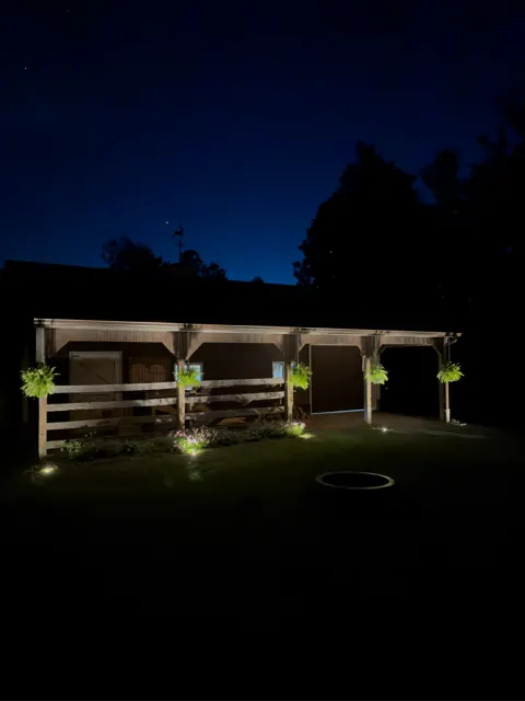 Covered porch with hanging baskets and path lights