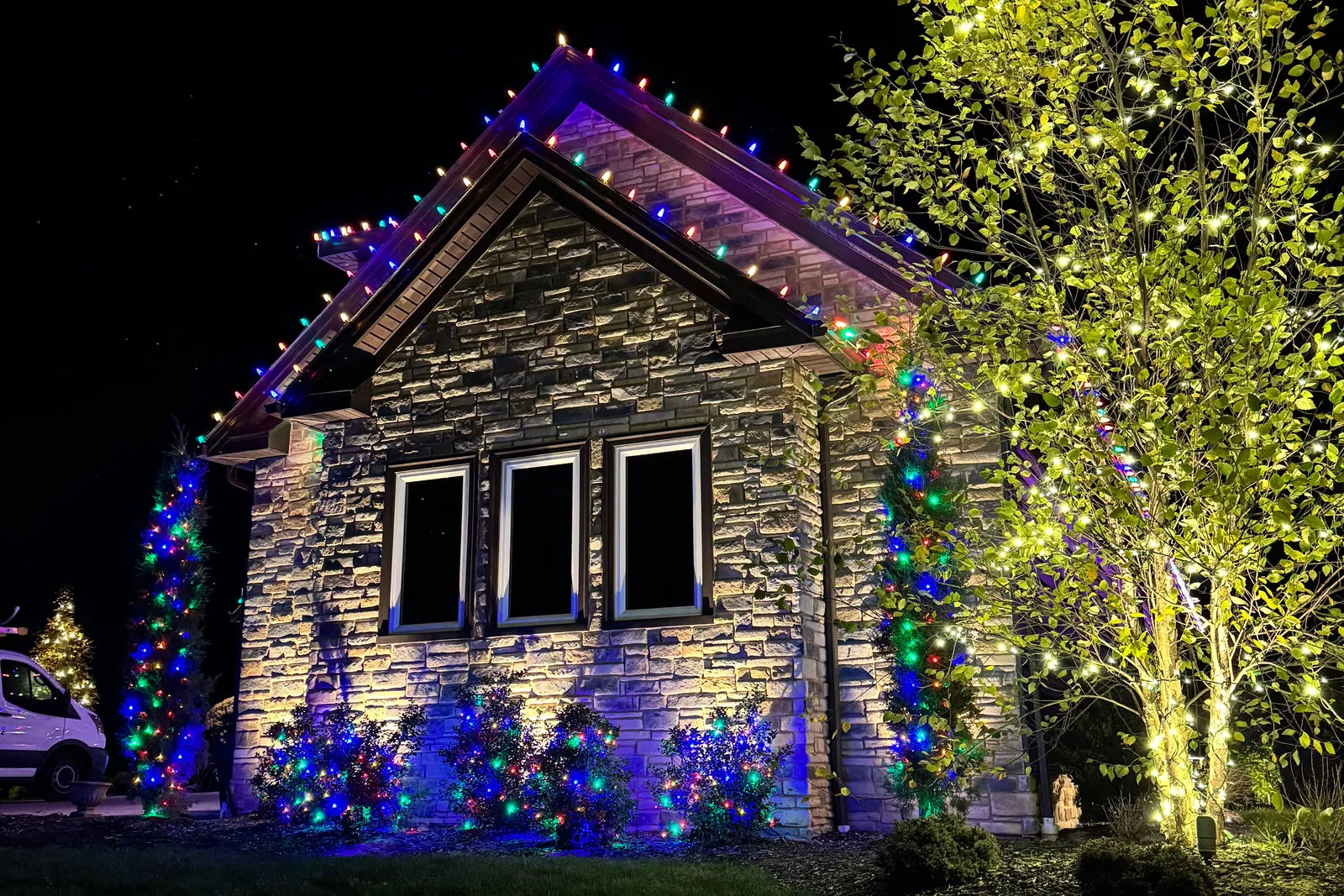Programmable roofline lights showing blue and purple on a two-storey home