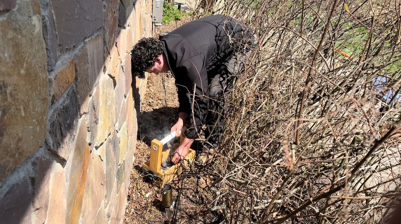 Technician performing landscape lighting maintenance
